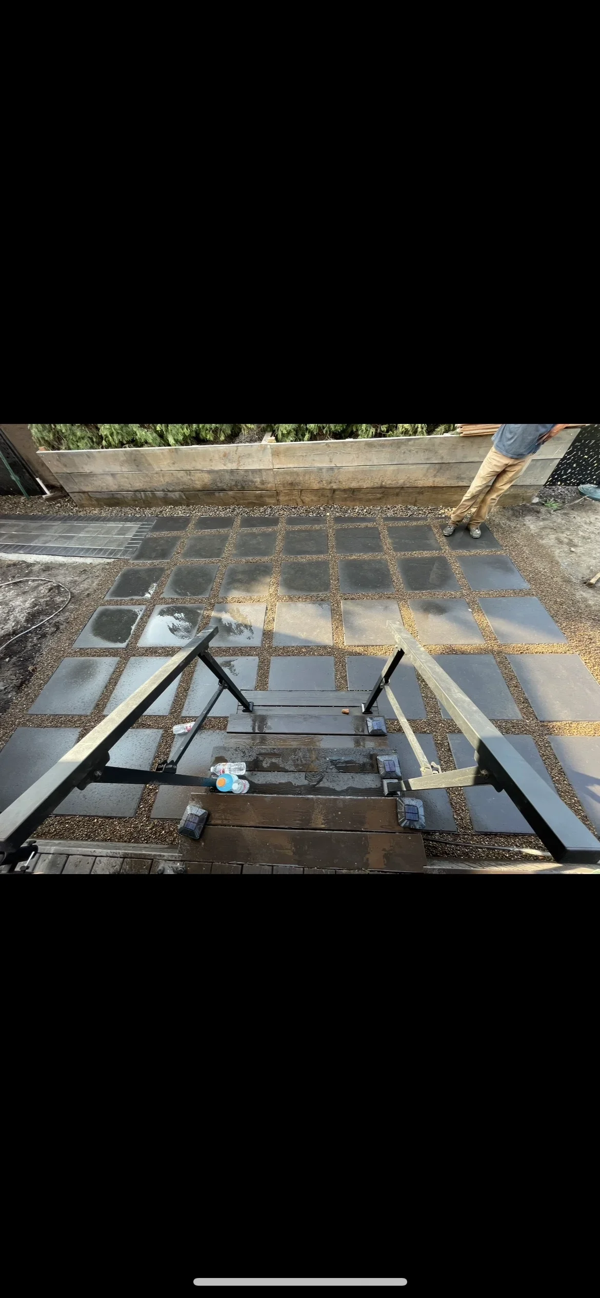 Permeable concrete pavers installed in grid pattern with gravel joints and metal leveling frame