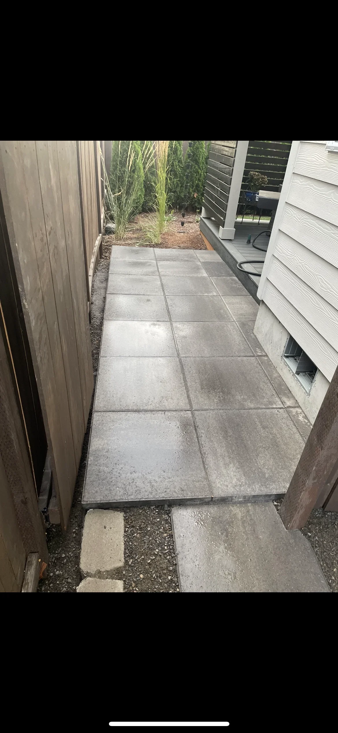 Gray concrete pavers installed in side yard walkway with grout joints